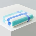 Thick blue and teal striped cotton towel folded on a geometric white platform pedestal - 34*76cm / Deep and Light Blue