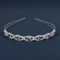 Close-up of wavy silver tiara featuring blue gemstones and sparkling rhinestones - Blue Rhinestone Wave Style (DFK998 Large Blue Rhinestone)