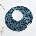 Detail eines Baby-Lätzchens mit Leopardenmuster, Druckknöpfen und strukturierter Baumwolle - Oval / Marineblau