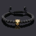 Detail of a golden leopard head charm with green eyes on a black beaded men's bracelet - Black Bracelet Gold Wolf Head