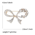 Broche nœud dorée élégante avec strass, largeur 4,5 cm, détails de poids sur fond blanc - Doré