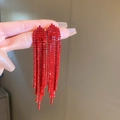 Detailaufnahme der langen roten Strass-Fransenohrringe mit glitzernden Quasten für Damen - Pfeil Quastenstil / Rot