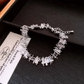 Macro shot of silver-tone irregular branch chain with baguette zircons and lobster clasp - Bracelet - Silver