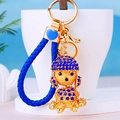 Exquisito llavero dorado con un caniche de strass azul y una correa de cuero trenzado - Cuerda Azul Real + Caniche Azul Real