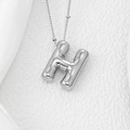 Macro shot of puffy 3D letter H balloon pendant on a delicate silver chain necklace - Letter H Pendant