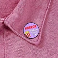 Macro detail of HORROR MOVIE LOVER enamel pin badge on a pink denim jacket collar - Horror Addicts Club (XZ8906)