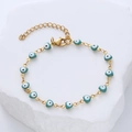 Golden chain bracelet featuring turquoise heart charms with Evil Eye patterns - Emerald