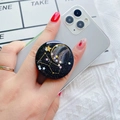 Close-up of starry galaxy phone socket holder with glitter finish on a grey smartphone - Black Base Mars