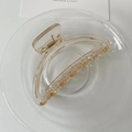 Close-up of elegant amber translucent hair claw clip on transparent tray with white card - Large / Transparent Yellow