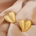 Textured gold heart earrings with 3D ribbed design displayed on elegant satin fabric - Ribbed 3D Heart Style