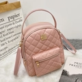 Pink quilted school backpack with gold hardware on a plush white rug background - Diamond Pattern / Pink