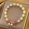 Elegant beaded bracelet with cat eye stones and silver bells on golden satin background - Silver Iridescent Cat Eye Bell Bracelet (X761)