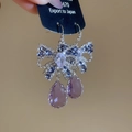 Macro detail of butterfly earrings featuring purple pear-cut crystals and blue zircons - Purple Ear Hooks