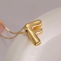 Minimalist gold balloon letter F pendant necklace with a polished metallic finish - Letter F