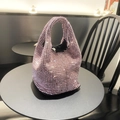 Detail shot of a pink rhinestone bucket bag with sparkling crystals on a cafe table - Pink