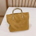 Detail of mustard yellow canvas tote bag with cream leather handles and metal rivets - Camel