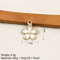 Detail view of flower pendant with white enamel petals, gold edges, and a pearl center - White (Pearl)