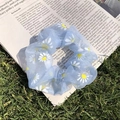 Light blue organza scrunchie with white and yellow daisy print on newspaper - Blue Mesh Daisy