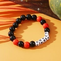 Beaded Halloween bracelet with black and red beads featuring the word TREAT in white letters - Halloween TREAT Letters Black Red