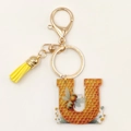 Detail of 2D acrylic letter U keychain with honeycomb pattern, bee motif and yellow tassel - Letter U
