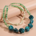 Detailed macro view of green marble beads and textured turquoise stones on a layered necklace - Green