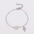 Detailopname van zilveren roestvrijstalen armband met kruis en religieuze muntbedel - Staalkleur