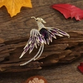 Golden phoenix brooch with purple enamel and sparkling rhinestones on dark bark - Purple Gemstone Phoenix