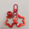 Red acrylic star keychain with metal bell and hollow star charm in solid red finish - Red