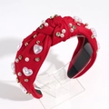 Detailed view of red knotted headband featuring heart pearls and sparkling rhinestones - Red