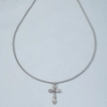 Macro shot of a silver vintage cross pendant with ornate textures and hip-hop style chain - Antique Silver