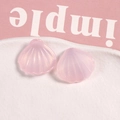 Vue macro de deux breloques en résine rose en forme d'éventail avec paillettes dorées fines - Rose