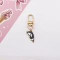Close-up of a cute black and white alloy cat keychain with a polished gold lobster clasp - Black and White Cat