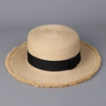 Detailed view of the woven raffia boater hat texture with stylish frayed edges and black ribbon - M (56-58cm) / Black Strap