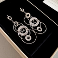 Detailed view of silver knotted hoop earrings with hammered texture on black velvet - Silver (Silver Pin) / Silver
