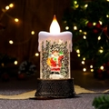 Gros plan d'une bougie de Noël à eau festive avec Père Noël et socle en bronze - Père Noël Bronze Avec Sac à Dos