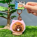 Capybara plush keychain in pink hooded cloak with a bell and brown metal clip - Pink Pig Headwear