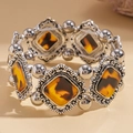Dettaglio del bracciale elastico geometrico in acrilico con finitura argento antico e resina - Ambra