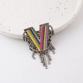 Close-up of V-shaped brooch with rainbow stripes, rhinestones and fringe tassels - Letter V