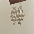 Detail of silver long tassel butterfly earrings with layered hollow metallic design - Silver Filigree Butterfly Tassel