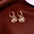 Close-up of 18K gold plated hoop earrings with white rocking horse pendant on red fabric - Ear Buckle-Gold-Pink-Real Gold Plated