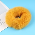 Soft bright yellow plush scrunchie hair tie on a light blue background decoration - Yellow
