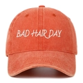 Détail de la broderie BAD HAIR DAY sur une casquette de baseball orange délavée - Taille unique / Orange