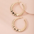 Detailed view of large gold hoop earrings featuring a geometric diamond-cut texture finish - Diamond-Cut Faceted Hoop