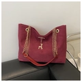 Detalle de bolso de ante rojo con colgante de ciervo dorado y correa de cadena metálica - Rojo