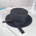 Detailed view of a black woven straw boater hat featuring a stylish dotted ribbon bow - M (56-58cm) / Black