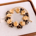 Detailed macro view of gold shell and leopard resin charms on a bohemian style necklace - Gold Leopard Print / Necklace