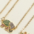 Vue macro du pendentif éléphant doré avec zircons colorés et détails de la chaîne fine - Collier Éléphant Zirconia (XL2700)