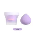 Spugna per trucco viola con il suo barattolo trasparente su uno sfondo bianco - Scatola di gelato Viola / Violetto