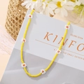 Detail of vibrant yellow beaded choker with white daisy charms on a lifestyle backdrop - Yellow Daisy Necklace