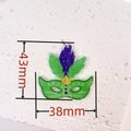 Macro view of green acrylic carnival mask pendant with fine glitter and 43mm x 38mm dimensions - Green and Purple Carnival Mask